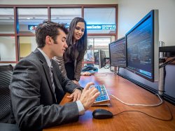 Students from the Feliciano School of Business analyzing stocks on double monitors.