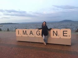 Student in front of sign reading Imagine