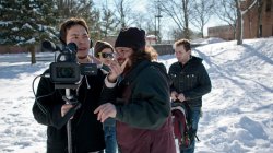 Student film crew making a movie on campus in winter