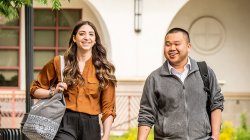 two students walking and smiling on campus